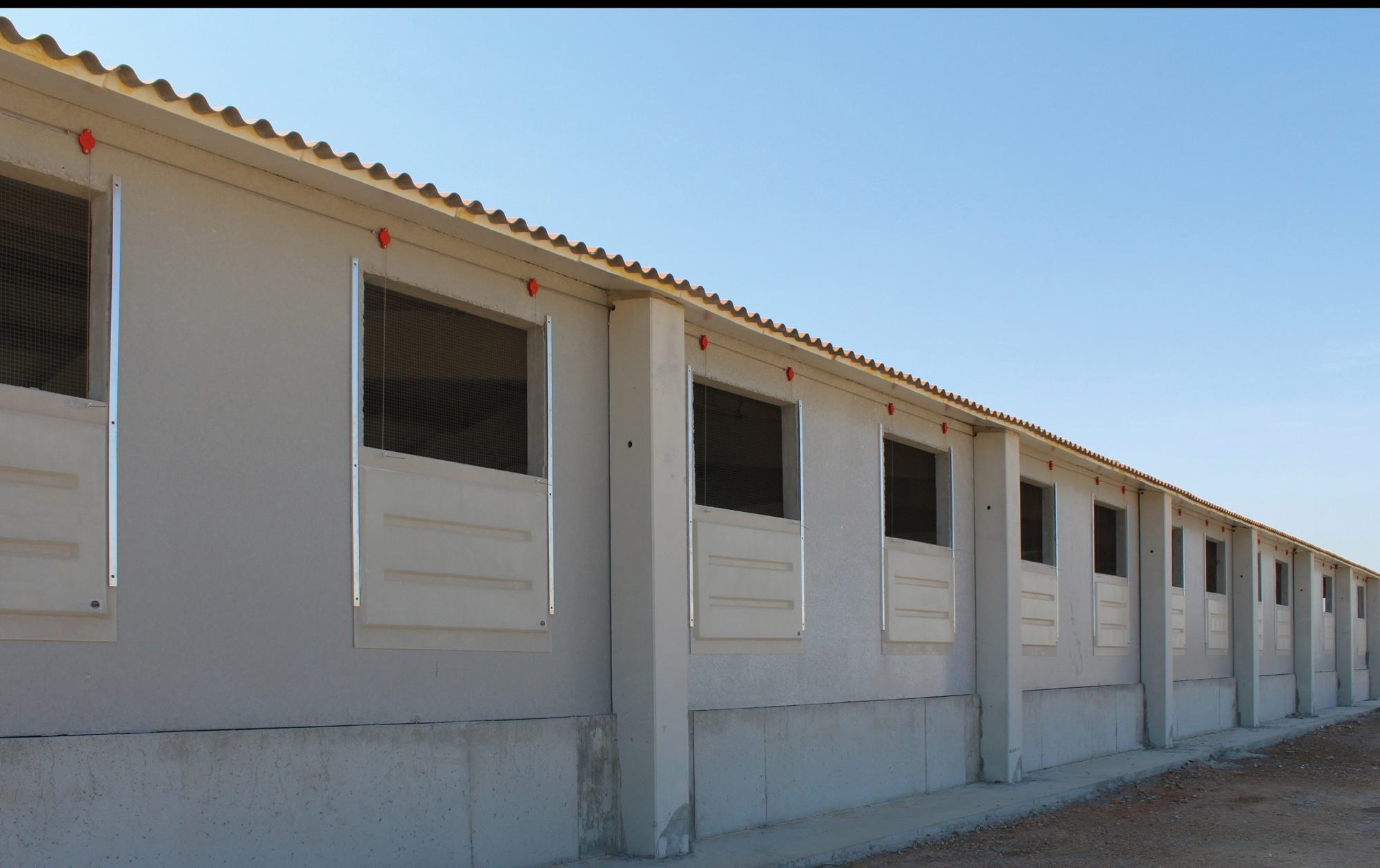 Fachada de una nave porcina con ventanas